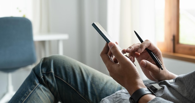 Cropped shot of businessman using mobile phone while sitting in modern office