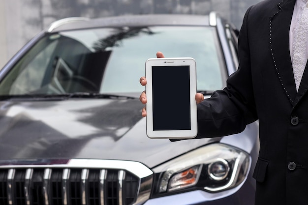 Cropped shot of car dealer sales wearing suit is holding blank screen tablet for mock up