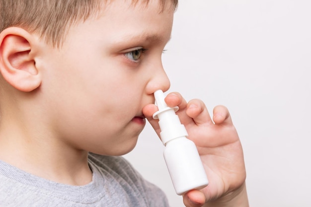 Cropped shot of a caucasian child using nasal spray for a runny nose and congestion