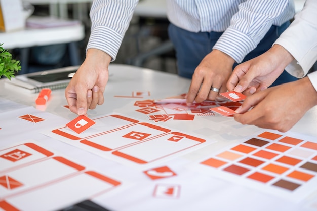 Cropped shot of creative UX UI designers team designing. Developing mobile application from prototypes and wireframe layout.