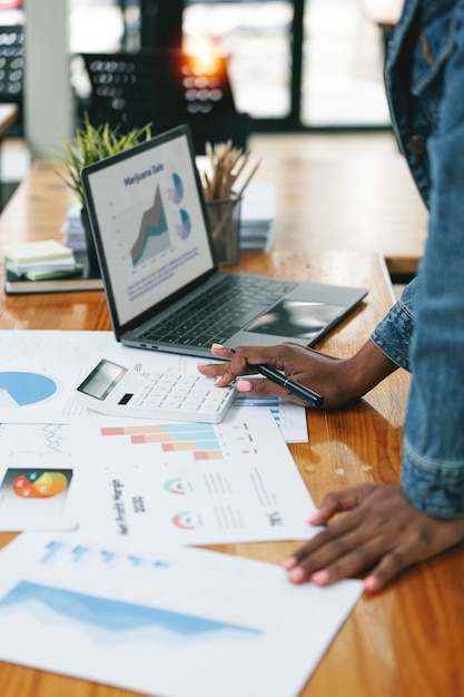 Cropped shot of ethnic businesswoman working document analyzing business graph chart planning finance and marketing investment on her desk office