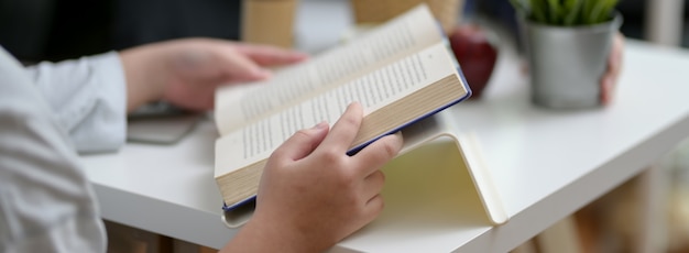 Cropped shot of female university student reading a book