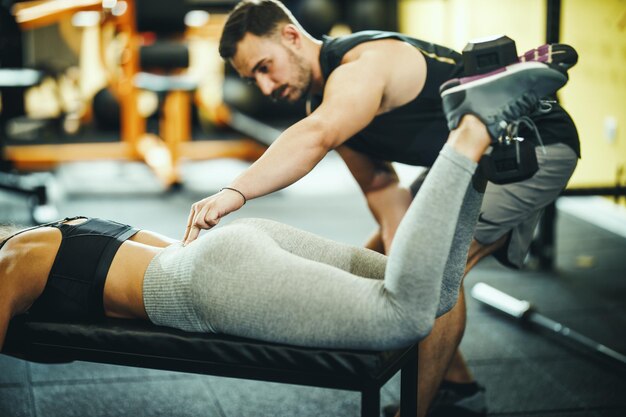 Cropped shot of a fit young woman doing exercises for gluteus with her personal trainer at the gym.