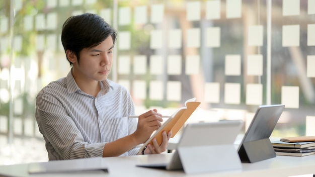 Cropped shot of male entrepreneur focusing on his task in glass wall office room