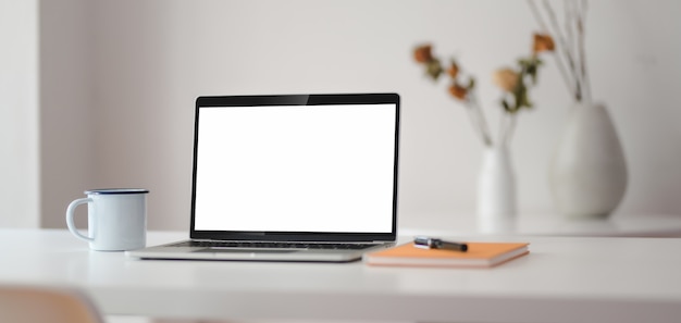 Cropped shot of modern workplace with open laptop computer with office supplies