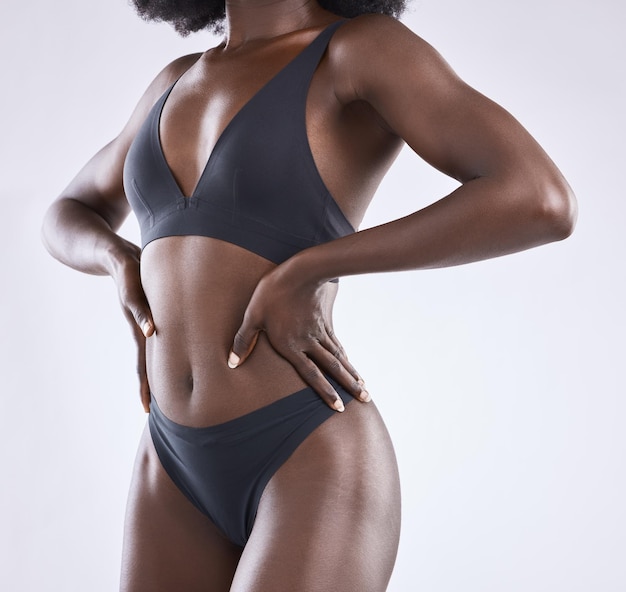 Cropped shot of a woman showing off her body against a studio background