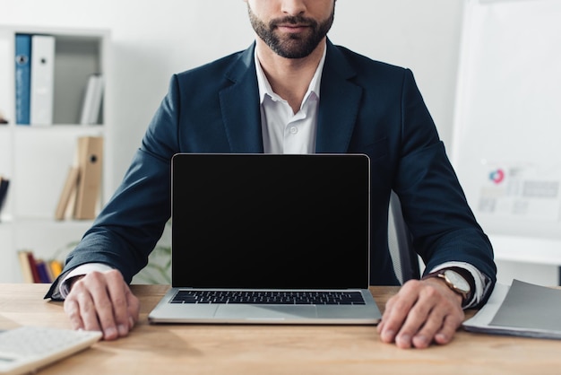 Cropped view of advisor in suit showing laptop with copy space