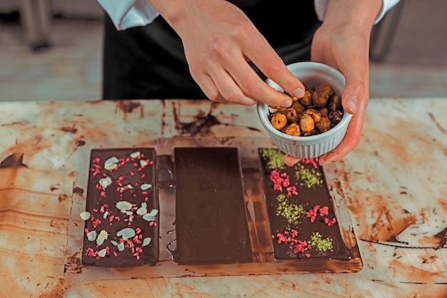 Photo cropped view chocolatier holding bowl