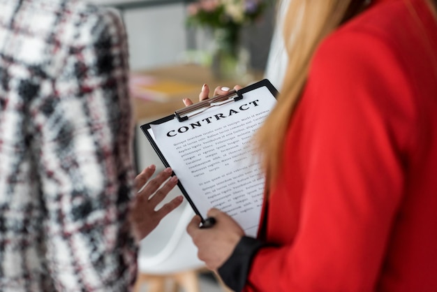 cropped view of magazine businesswomen working with contract