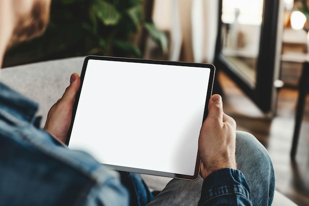 cropped view of man holding digital tablet with blank screen at home