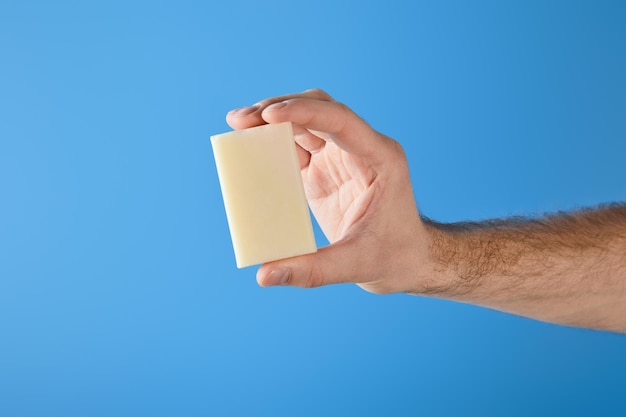 Cropped view of man holding soap isolated on blue