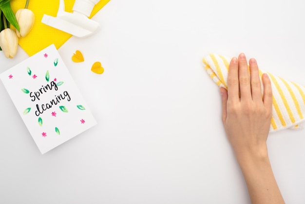 Cropped view of woman holding rag near spring tulips yellow cleaning supplies spring cleaning card