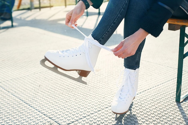 Cropped view of woman tying shoe laces on ice skates banner