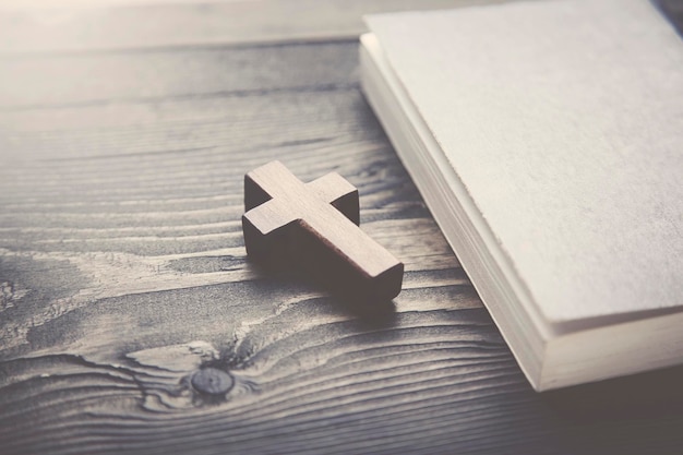 Cross and book on a wooden table