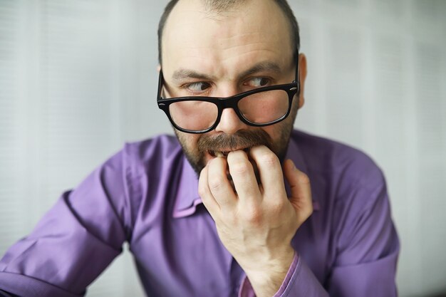 A cross-eyed bearded man is looking into the frame. Eye disease. The concept of an inexperienced specialist. Spy neighbor.