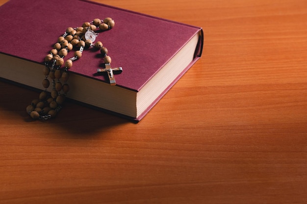 Cross on the holy bible on a wooden table