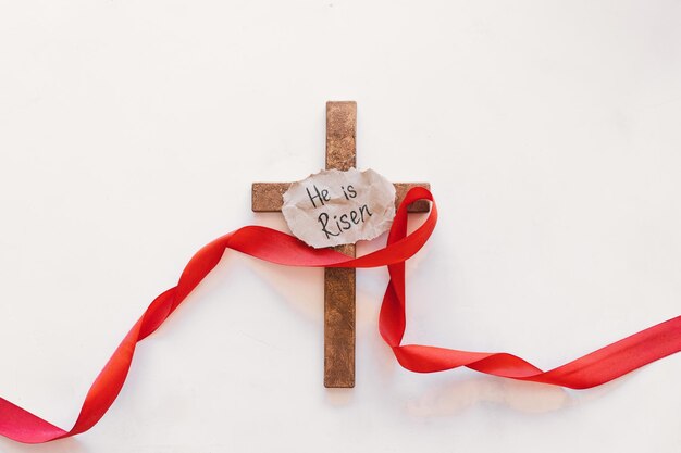 Cross with a red ribbon a symbol of Christ Crucifixion Of Jesus Christ Passion Of Jesus Christ Concept for faith spirituality and religion Easter Day