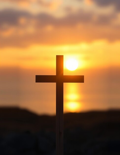 a cross with the sun setting behind it