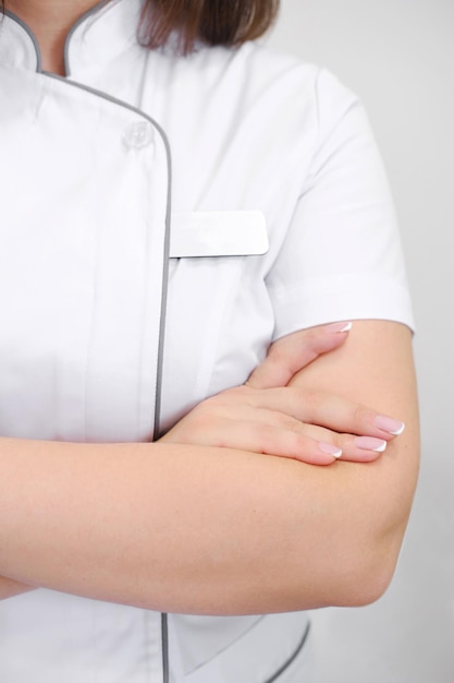 Crossed arms of a medical worker in a white coat Closeup