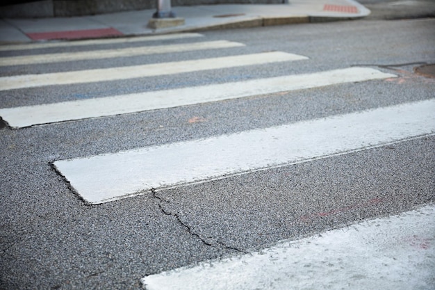 A crosswalk with a white line that says " walk " on it.