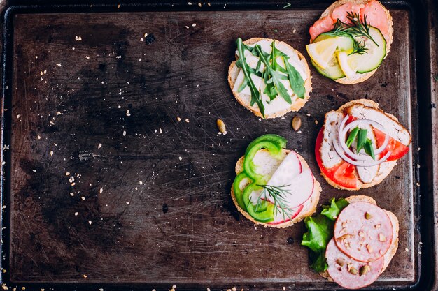 Photo crostini with different toppings on black table background. 