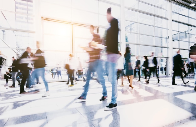 crowd of anonymous blurred people walking in a modern floor. ideal for websites and magazines layouts