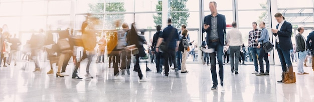 Crowd of anonymous people walking on a business center