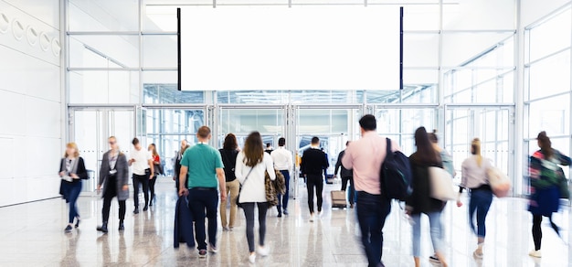 Crowd under blank billboard on trade fair