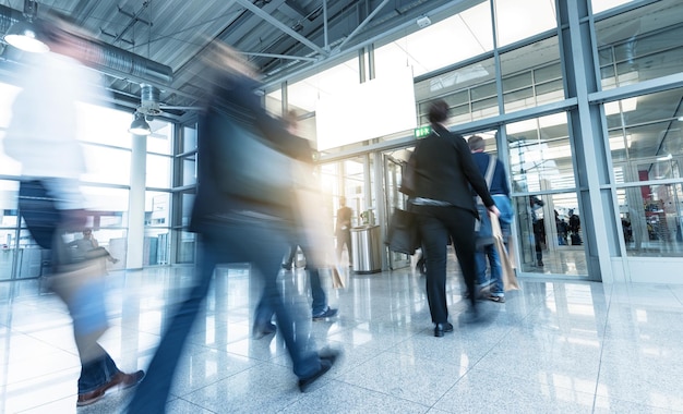 crowd of business commuters walking in a entrance at a trade show, including copy space banner. ideal for websites and magazines layouts