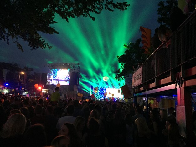 Photo crowd at music concert against sky at night