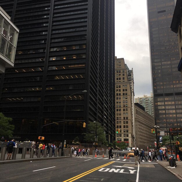 a crowd of people are gathered in a city with the number 1 on the side of the street