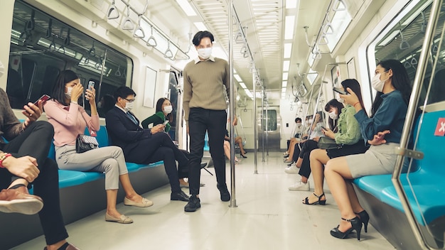 Crowd of people wearing face mask on a crowded public subway train travel