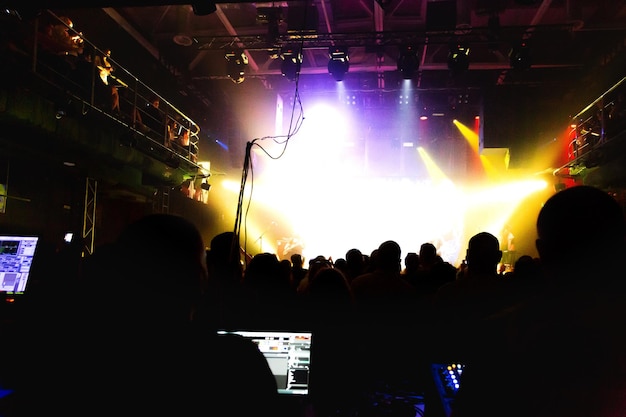 Crowd of spectators in front of the stage at a concert of a popular band