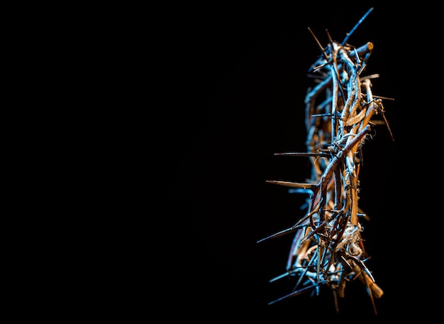 Crown of thorns with a blue tint of light in the dark. The concept of Holy Week, suffering and crucifixion of Jesus.