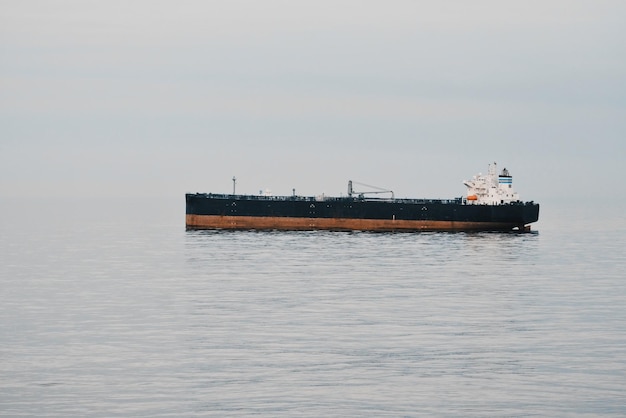 Photo crude oil carrier tanker at anchor making no way through the water