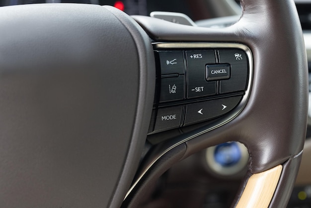 Cruise control speed limit and volume buttons on modern car steering wheel interior details hybrid