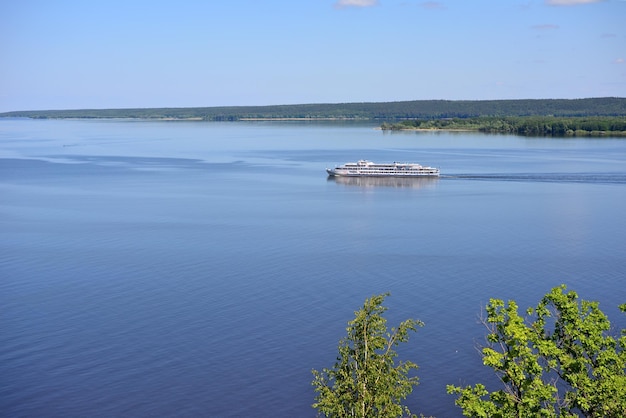 cruise ship on the Volga river with bank and island on horizon in sunny day