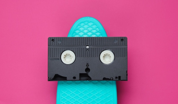 Cruiser board and video cassette on pink paper