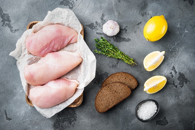 Crumbed uncooked chicken breasts ingredient  on grey background, top view