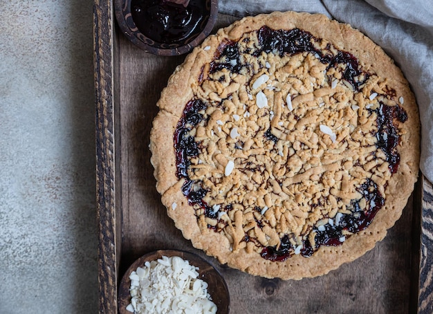 Crumble cake with jam in wooden tray Homemade streusel jam pie Top view Selective focus