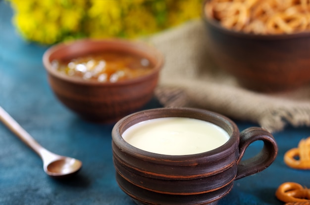  Crumbled pretzels on a textural background with milk in a clay cup