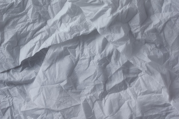 The crumpled background of the unfolded white paper