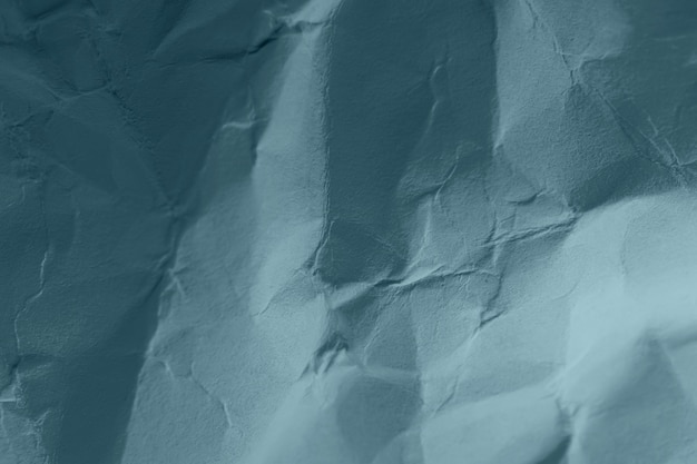 Crumpled paper in blue-green pastel color. Tidewater Green. Abstract trending background image.