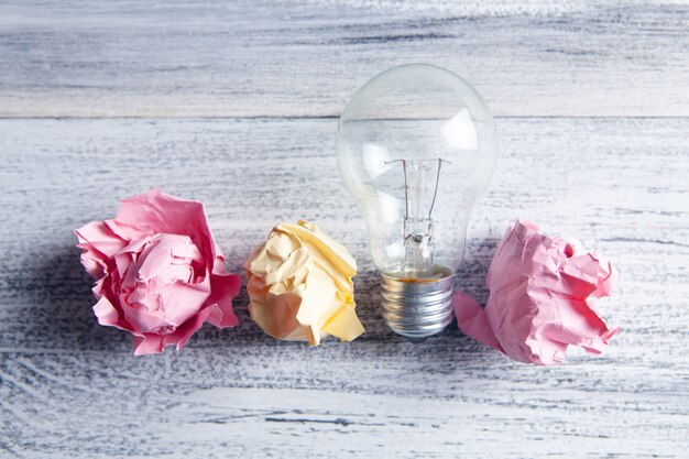 Crumpled papers and a light bulb on the table