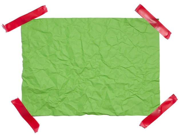 Crumpled rectangular sheet of green paper on a white background top view Place for inscription