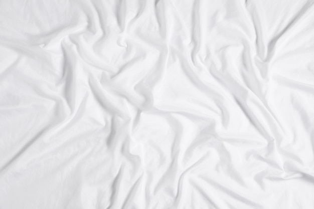 Crumpled white fabric as background top view