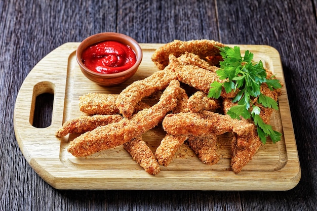 Crunchy Baked Chicken Tenders on a wooden board