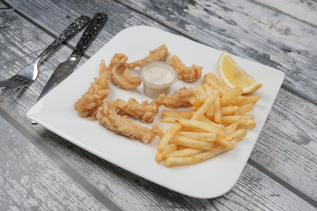 Crunchy deep fried squid stick and french fries on table