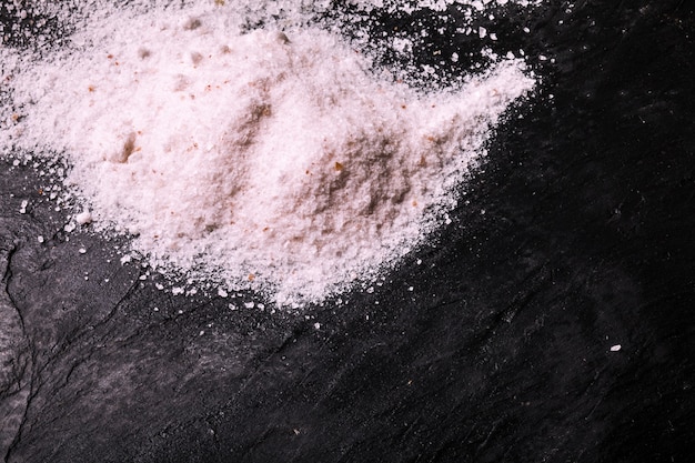 Crushed pink Himalayan salt on slate background