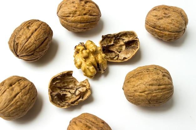 Crushed Walnuts On White Background. Whole and cracked walnuts on a white background,